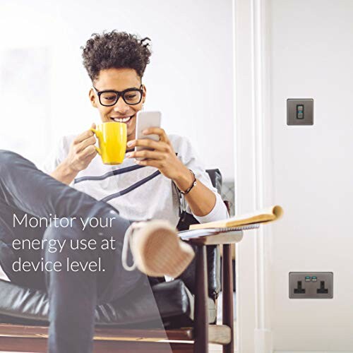 Man sitting and drinking coffee while using smartphone, with text about energy monitoring