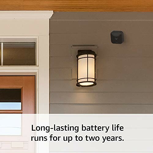 Outdoor security camera with long-lasting battery mounted near a porch light.